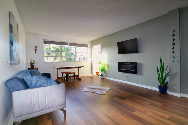 living room with a textured ceiling, dark hardwood / wood-style floors, and a healthy amount of sunlight