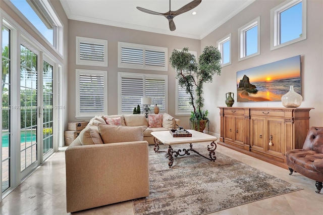 living room featuring ceiling fan, a towering ceiling, and crown molding