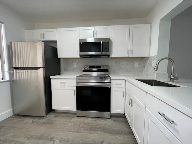 kitchen featuring tasteful backsplash, white cabinetry, sink, and appliances with stainless steel finishes