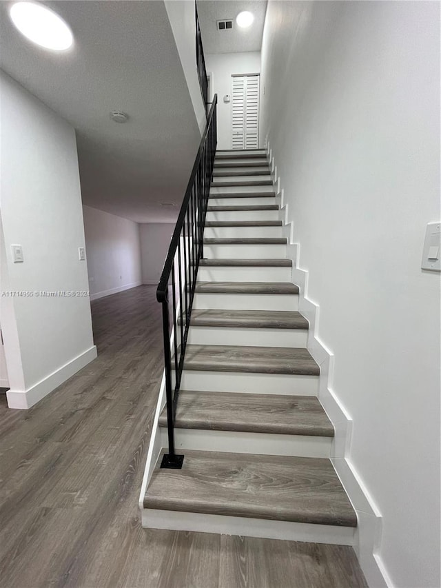 staircase featuring wood-type flooring