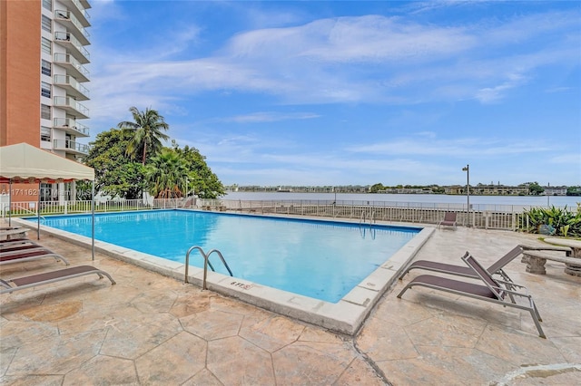 view of pool with a water view and a patio area