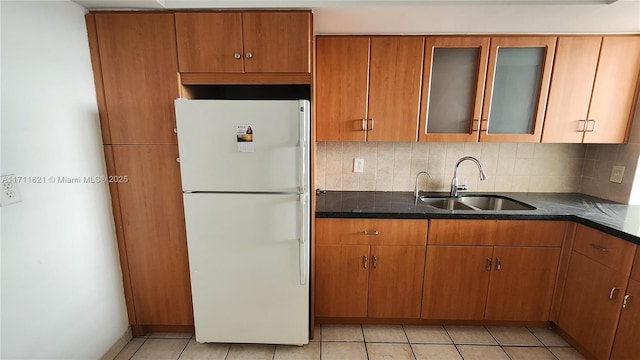 kitchen with sink, decorative backsplash, light tile patterned flooring, and white refrigerator