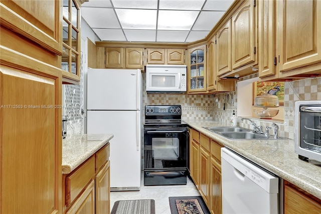 kitchen with a paneled ceiling, white appliances, sink, light stone countertops, and tasteful backsplash