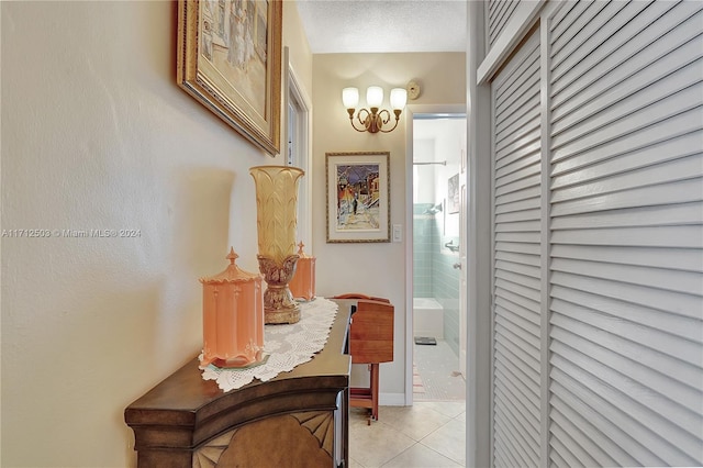 corridor with light tile patterned floors and a textured ceiling