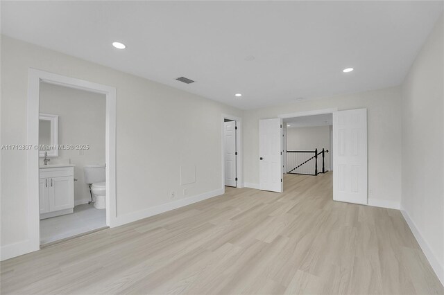 unfurnished room featuring light hardwood / wood-style flooring and sink