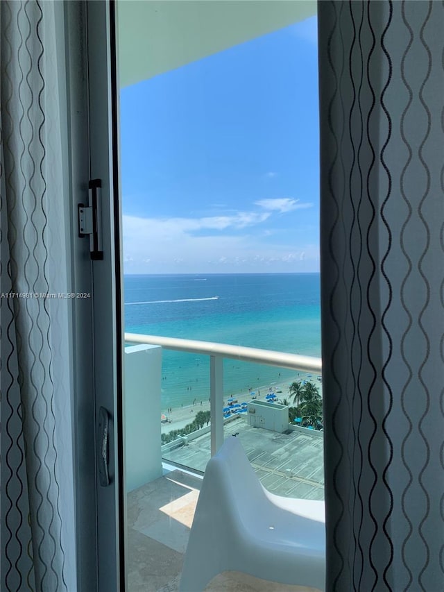 balcony featuring a water view and a view of the beach