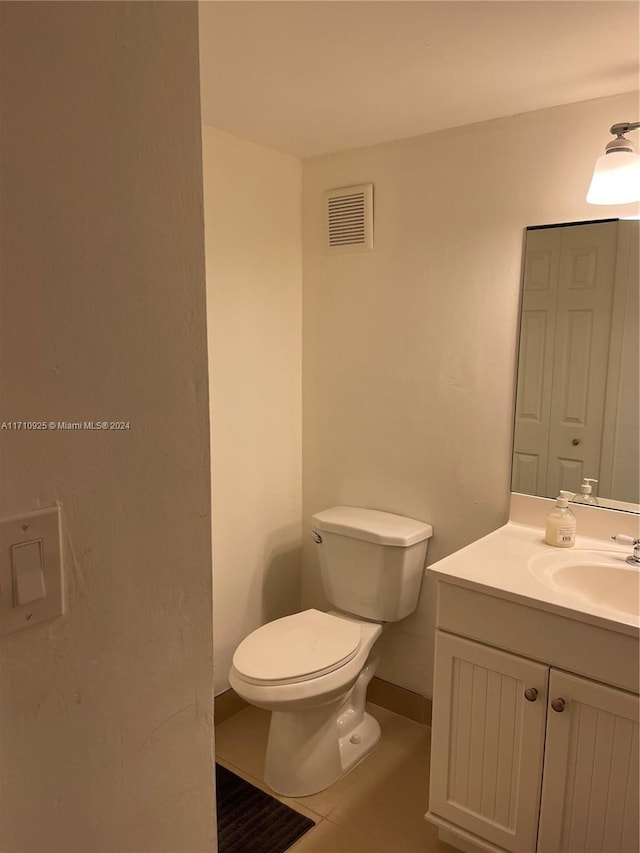 bathroom featuring tile patterned floors, vanity, and toilet