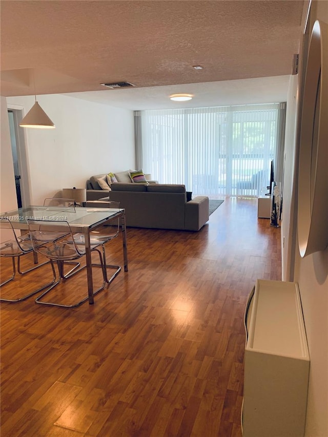 living room featuring a textured ceiling and dark wood-type flooring