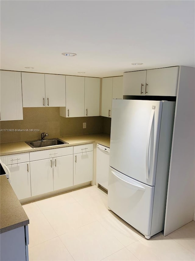 kitchen featuring light tile patterned flooring, white appliances, backsplash, and sink