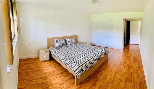 bedroom with light hardwood / wood-style flooring and a closet