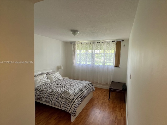 bedroom with wood-type flooring and a textured ceiling