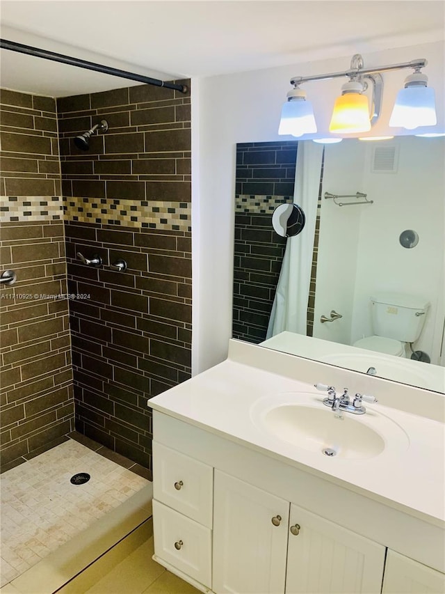 bathroom with toilet, vanity, and walk in shower