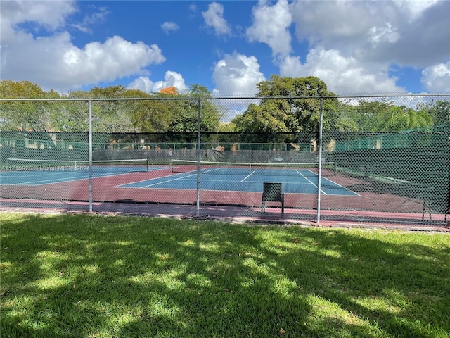 view of sport court with a lawn