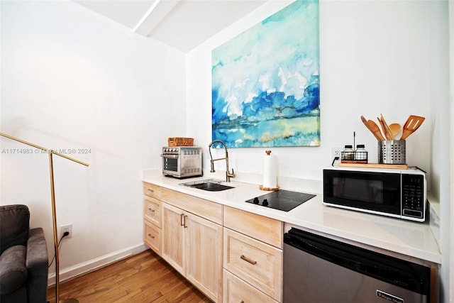 kitchen featuring sink, dishwasher, light brown cabinets, light hardwood / wood-style floors, and black electric cooktop