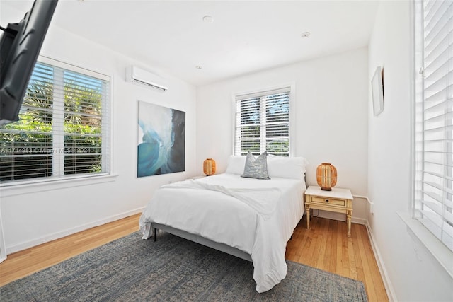 bedroom featuring a wall mounted air conditioner and hardwood / wood-style floors