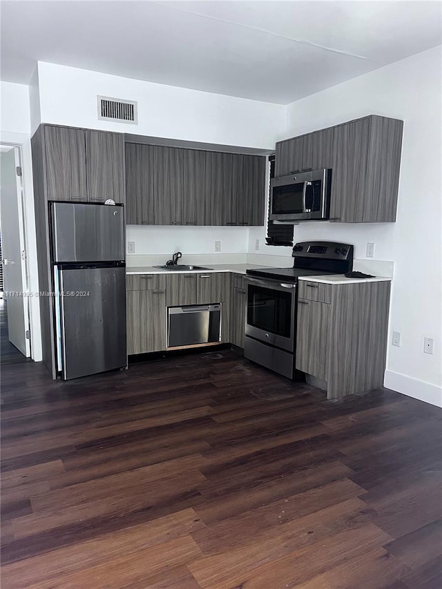 kitchen featuring dark wood-type flooring, sink, and stainless steel appliances