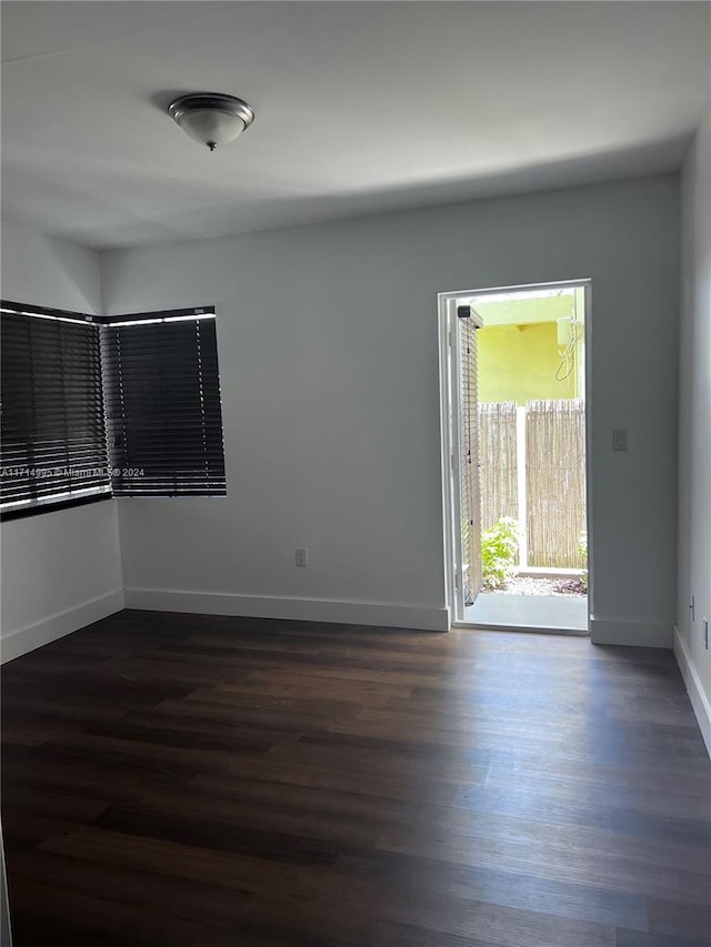 unfurnished room with dark wood-type flooring