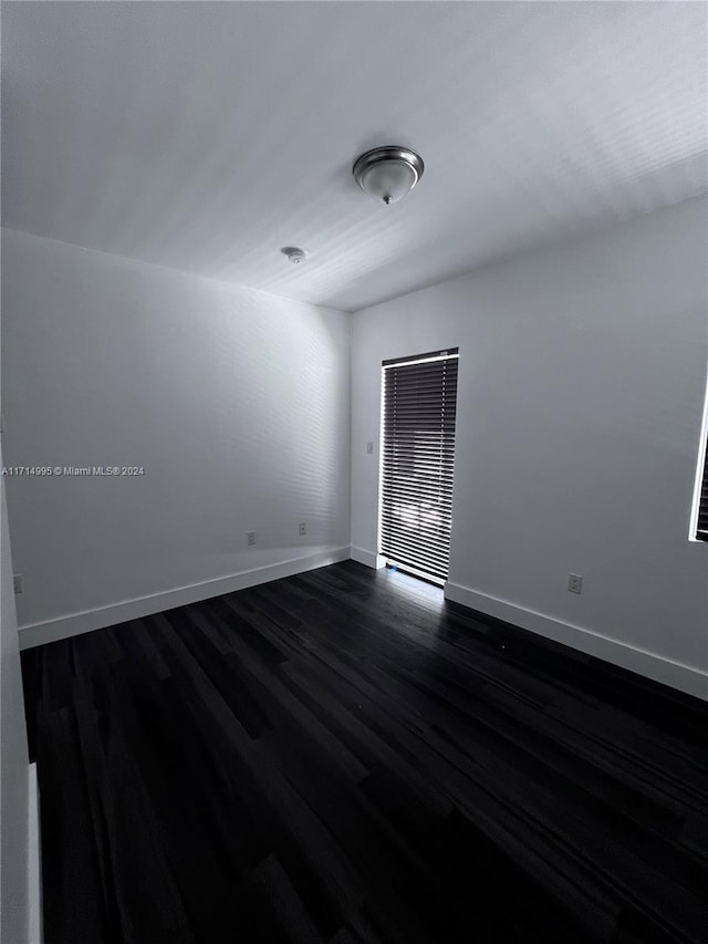 unfurnished room with dark hardwood / wood-style floors