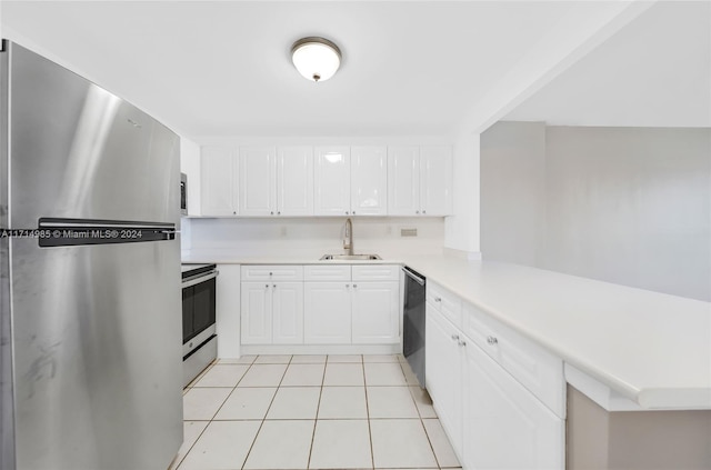 kitchen featuring white cabinetry, stainless steel fridge, sink, and range