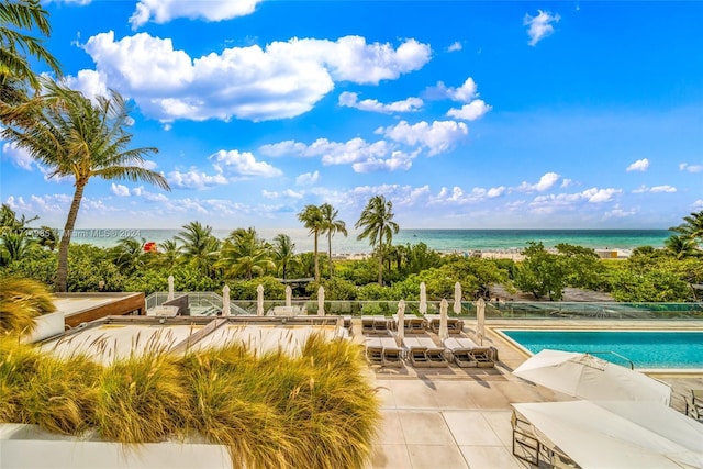 view of pool with a patio and a water view