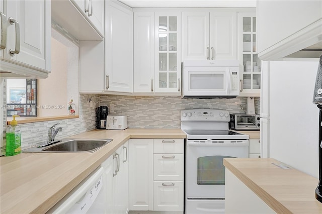 kitchen with white appliances, tasteful backsplash, white cabinetry, and sink