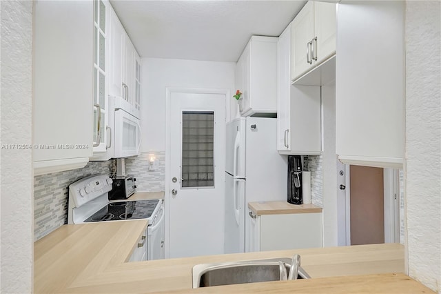 kitchen featuring tasteful backsplash, sink, white cabinets, and white appliances