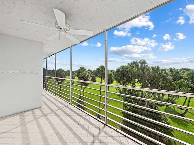 unfurnished sunroom with ceiling fan