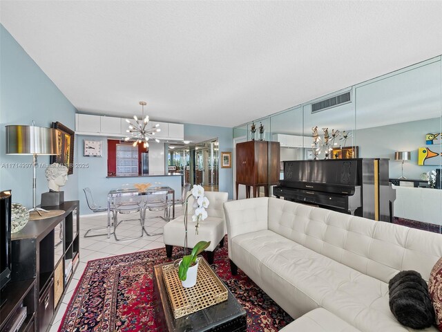 living room featuring light tile patterned flooring and an inviting chandelier