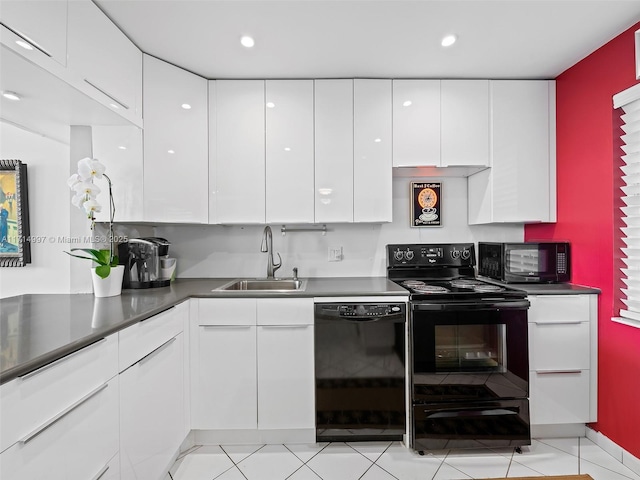 kitchen with dark countertops, a sink, white cabinets, black appliances, and modern cabinets