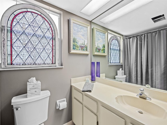 full bathroom with vanity, curtained shower, toilet, and visible vents