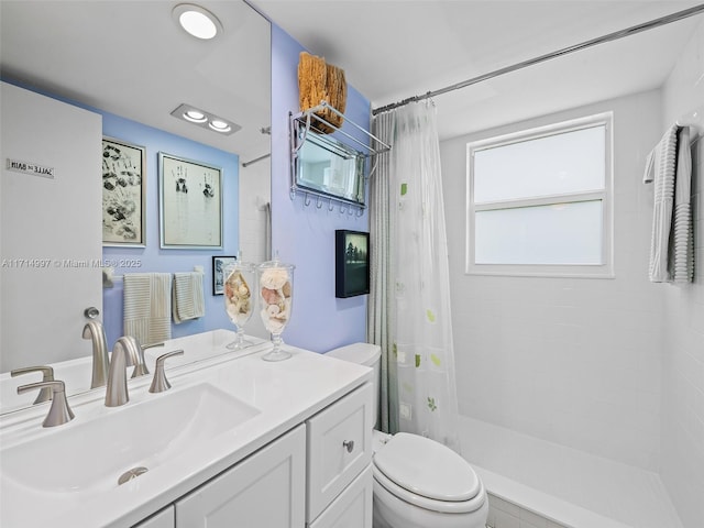 full bath with a tile shower, recessed lighting, toilet, and vanity