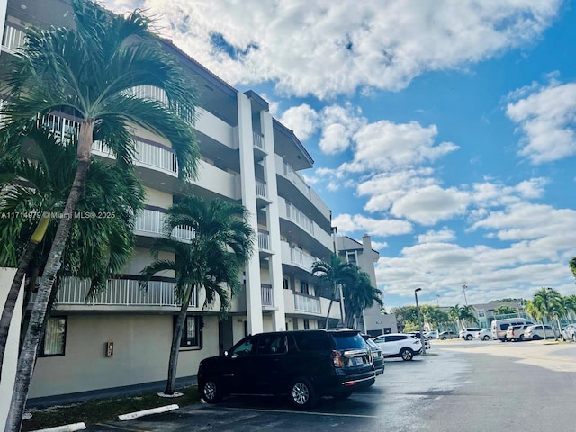 view of building exterior with uncovered parking