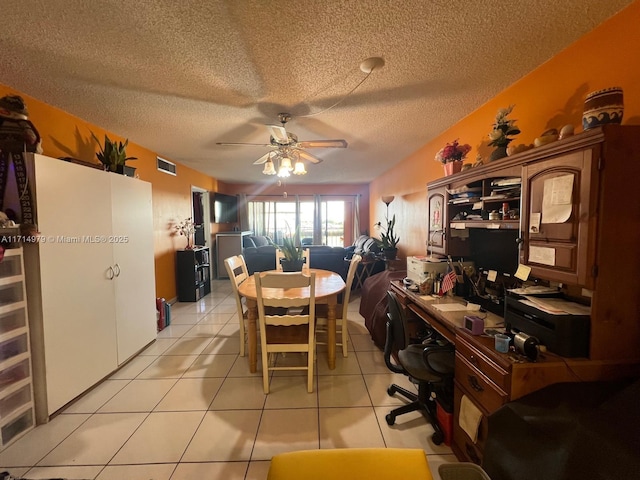 dining space featuring a textured ceiling, light tile patterned flooring, visible vents, and ceiling fan