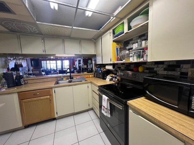 kitchen with visible vents, black appliances, a sink, light tile patterned flooring, and light countertops