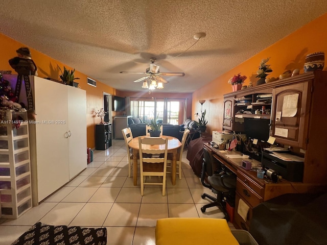 dining area with light tile patterned floors, visible vents, a textured ceiling, and a ceiling fan