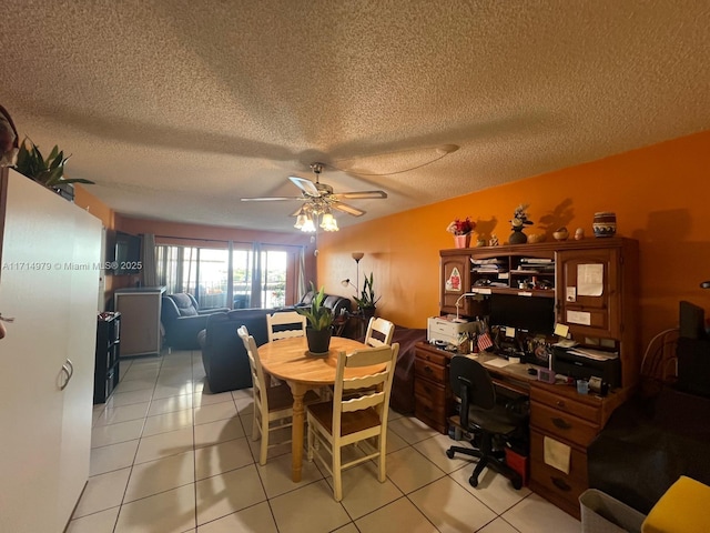 dining area featuring a textured ceiling, light tile patterned flooring, and a ceiling fan