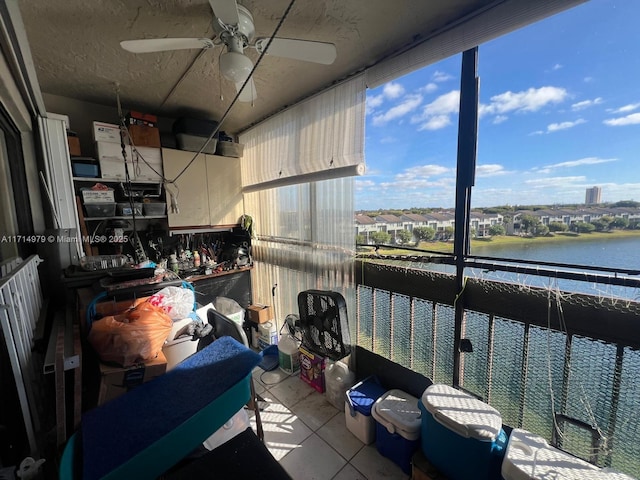 kitchen with tile patterned floors, a water view, and ceiling fan