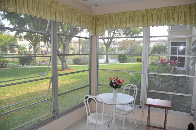 sunroom featuring a water view