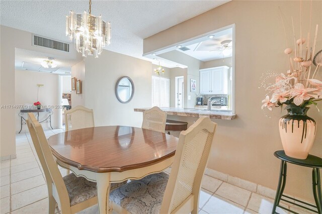 tiled dining area featuring ceiling fan and a textured ceiling