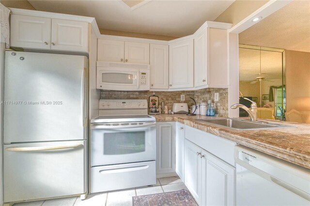 kitchen with sink, white cabinets, and white appliances