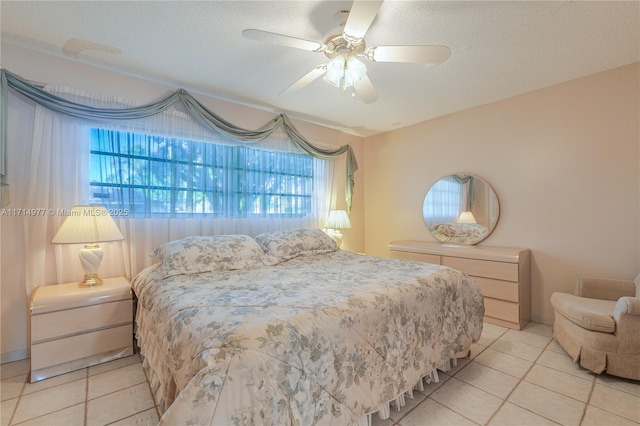 tiled bedroom with a textured ceiling and ceiling fan