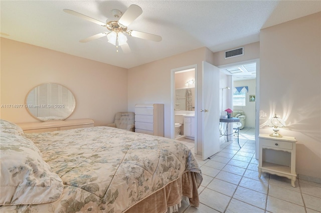 tiled bedroom featuring connected bathroom, ceiling fan, and a textured ceiling