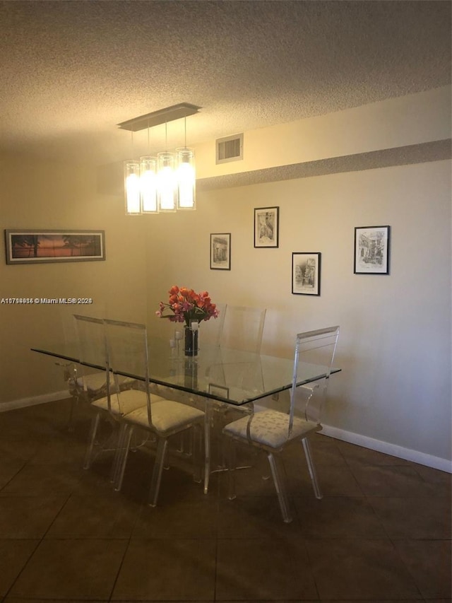 tiled dining space featuring a textured ceiling