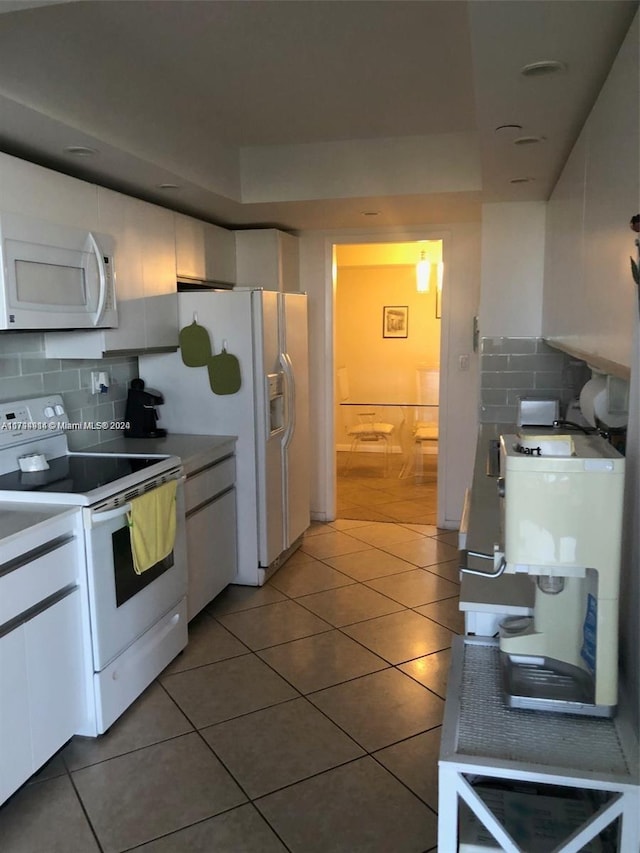 kitchen featuring decorative backsplash, white cabinetry, tile patterned flooring, and white appliances