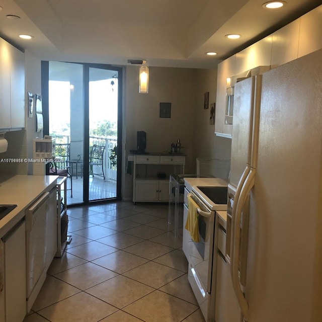 kitchen with white appliances, hanging light fixtures, light tile patterned floors, a wall of windows, and white cabinetry