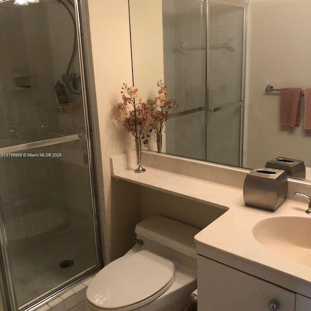 bathroom with an enclosed shower, vanity, and toilet