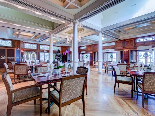 dining room featuring a notable chandelier, ornate columns, and coffered ceiling