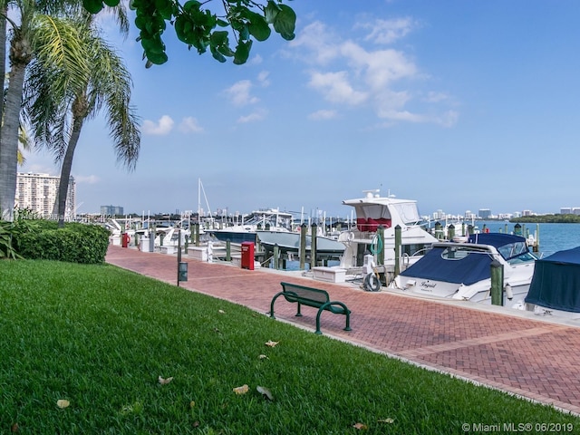 view of home's community featuring a lawn, a dock, and a water view