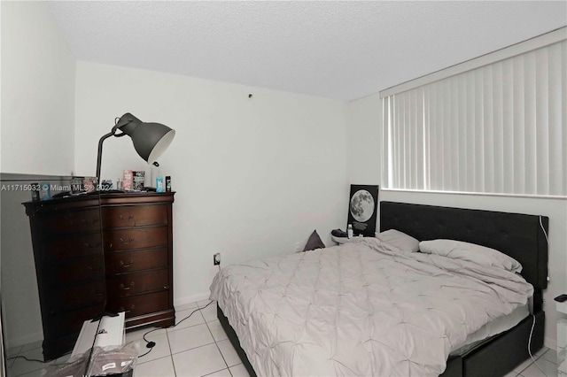 bedroom featuring light tile patterned floors and a textured ceiling