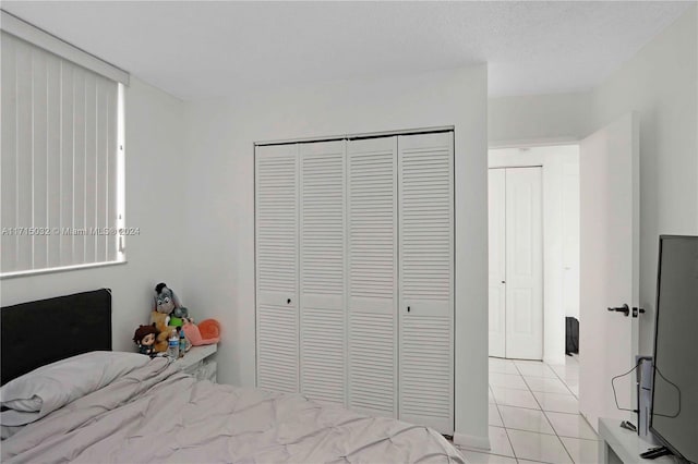 bedroom featuring light tile patterned floors and a closet